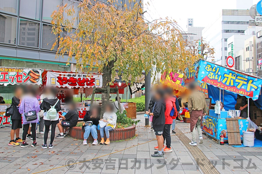 甲州街道・桑並木通りがクロスする交差点付近の屋台とお祭りを楽しむ人たちの様子